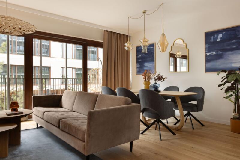 Stylowa przestrzeń z designerską sofą i elegancką jadalnią.