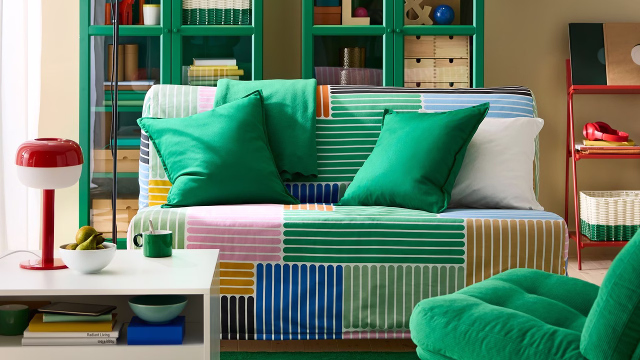Kolorowe wnętrze z zieloną sofą i designerską lampą.