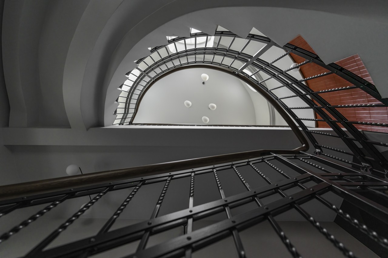 Kręcona klatka schodowa z elegancką metalową balustradą.