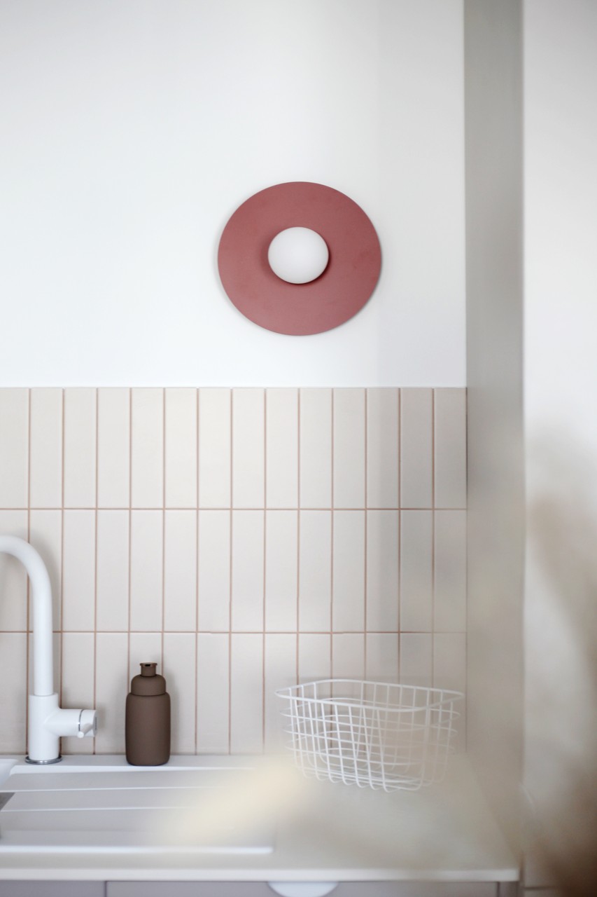 Minimalistyczna kuchnia z białą armaturą i dekoracją ścienną.
