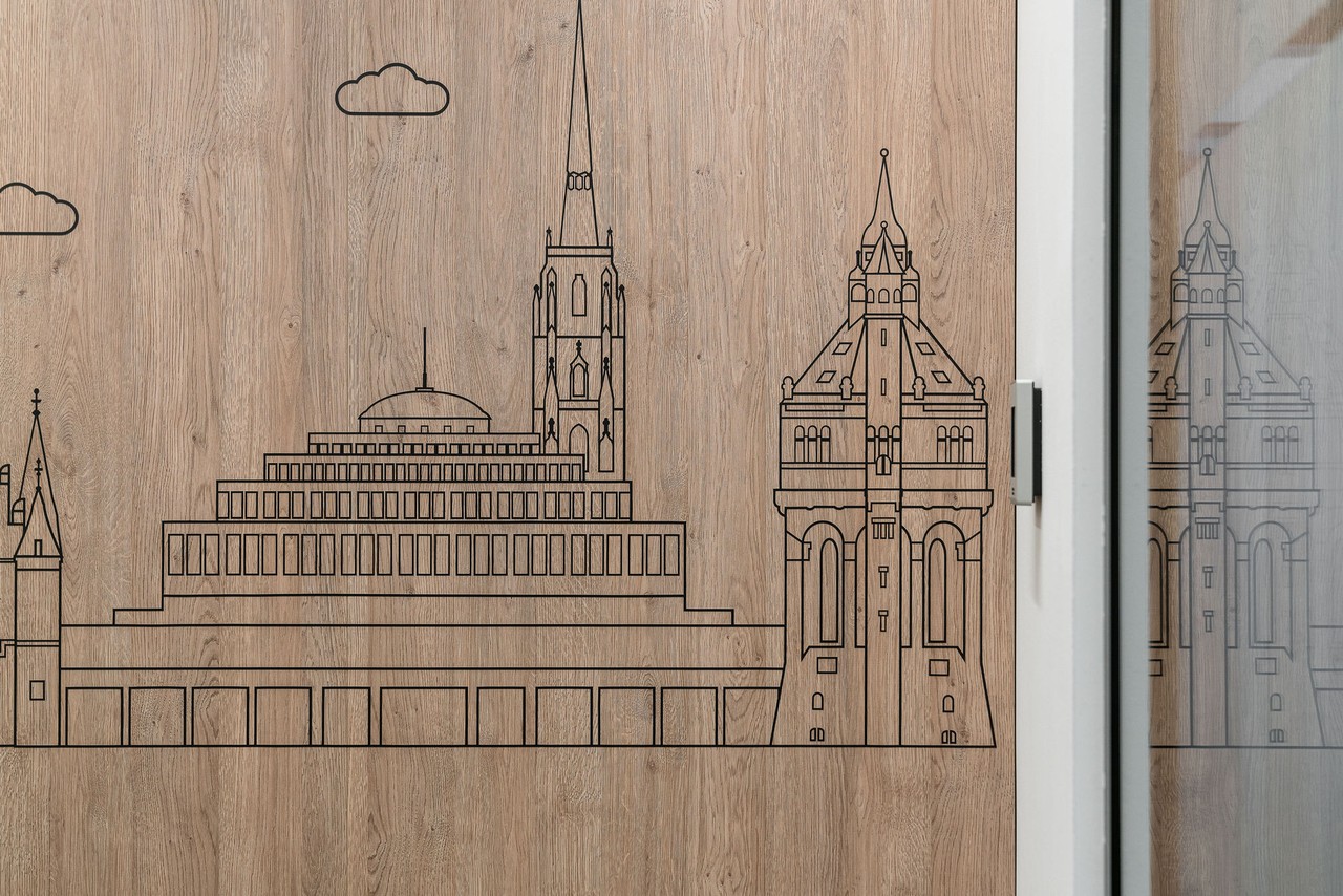 Ilustracja architektury na drewnianym panelu.