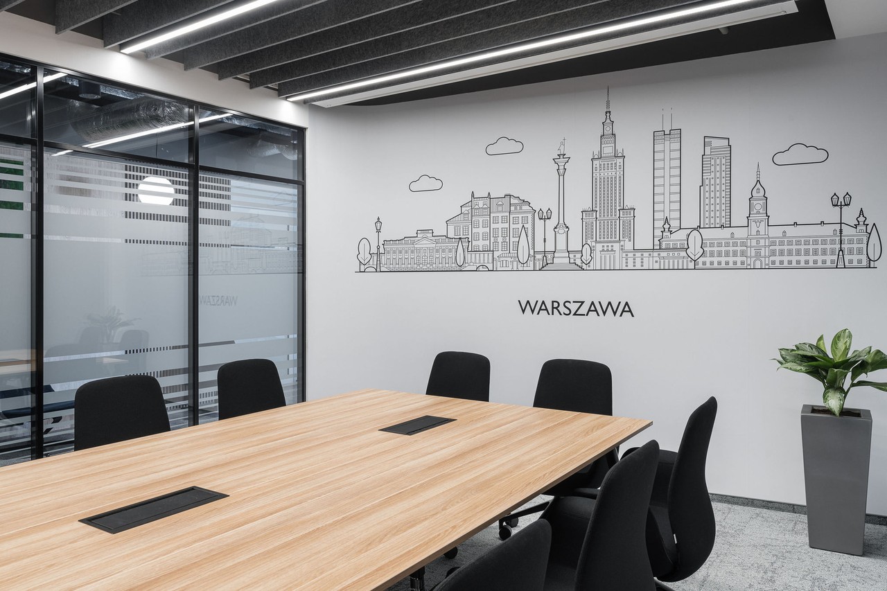 Nowoczesna sala konferencyjna z panoramą Warszawy na ścianie.