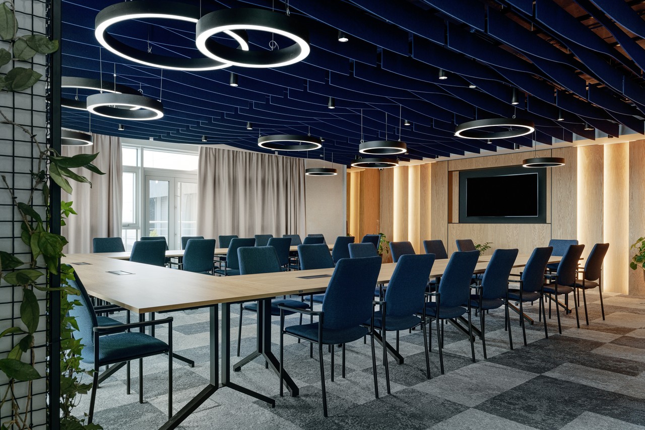 Nowoczesna sala konferencyjna z designerskimi lampami sufitowymi.