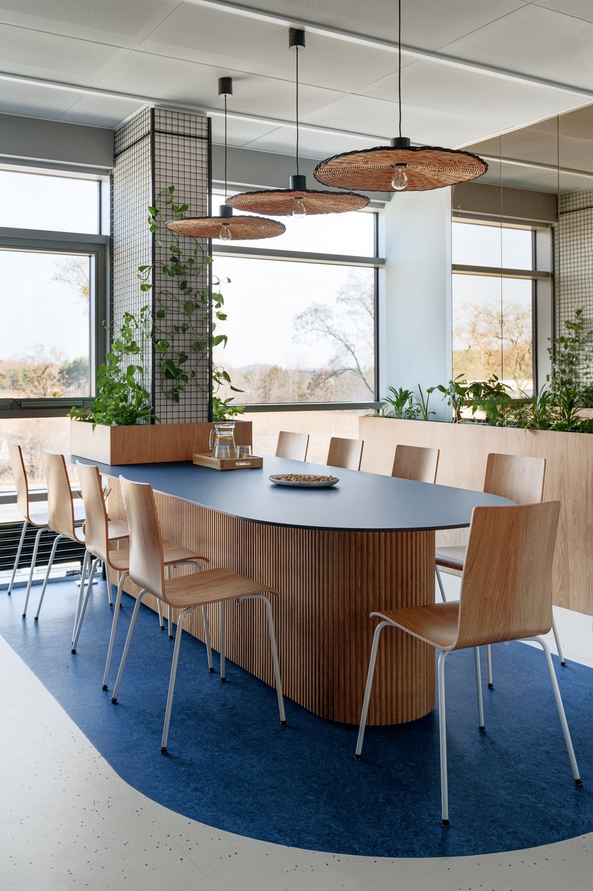 Nowoczesna jadalnia z drewnianym stołem i designerskimi lampami.