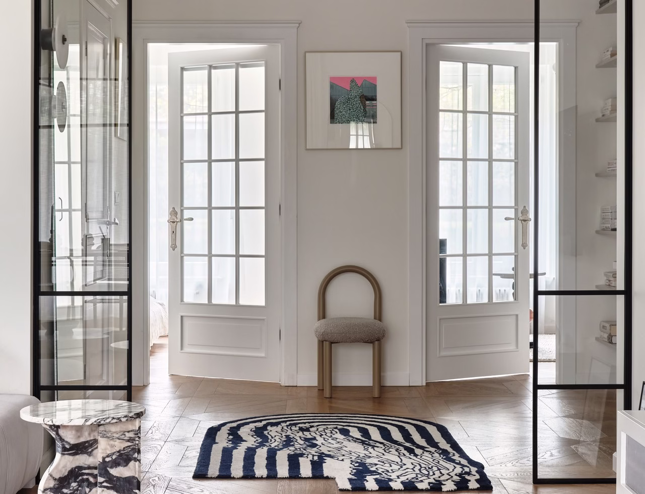 Elegancki przedpokój z designerskim dywanem i marmurowym stolikiem.