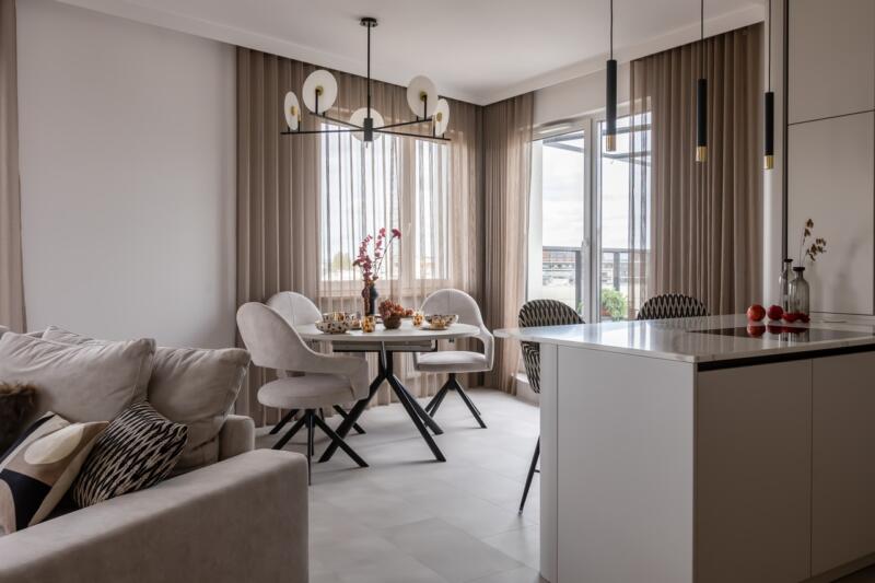 Elegancki salon z białym stołem i nowoczesnym oświetleniem.