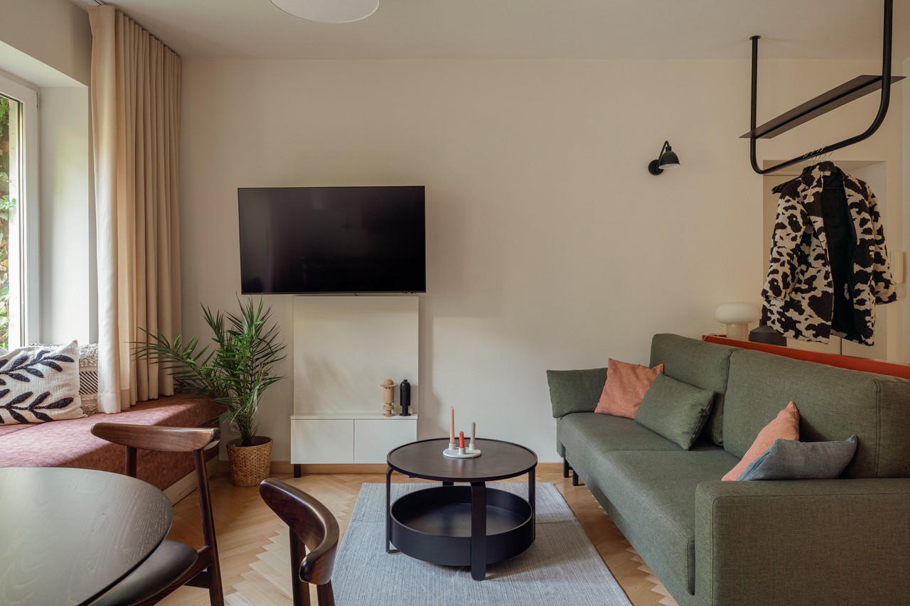 Przytulny salon z zieloną sofą i stylowym stolikiem kawowym.