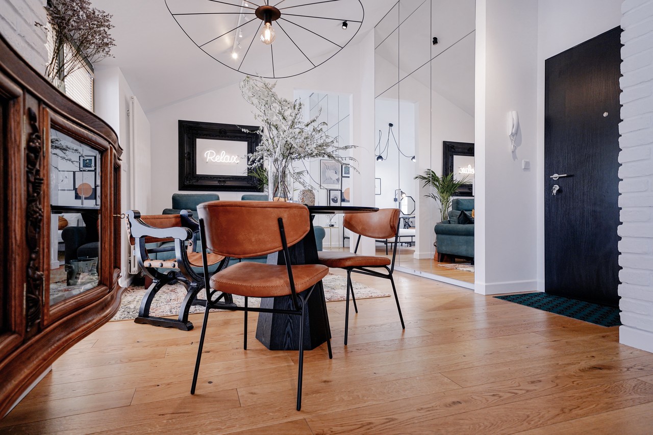 Wnętrze z designerskimi krzesłami i eleganckim lustrem.