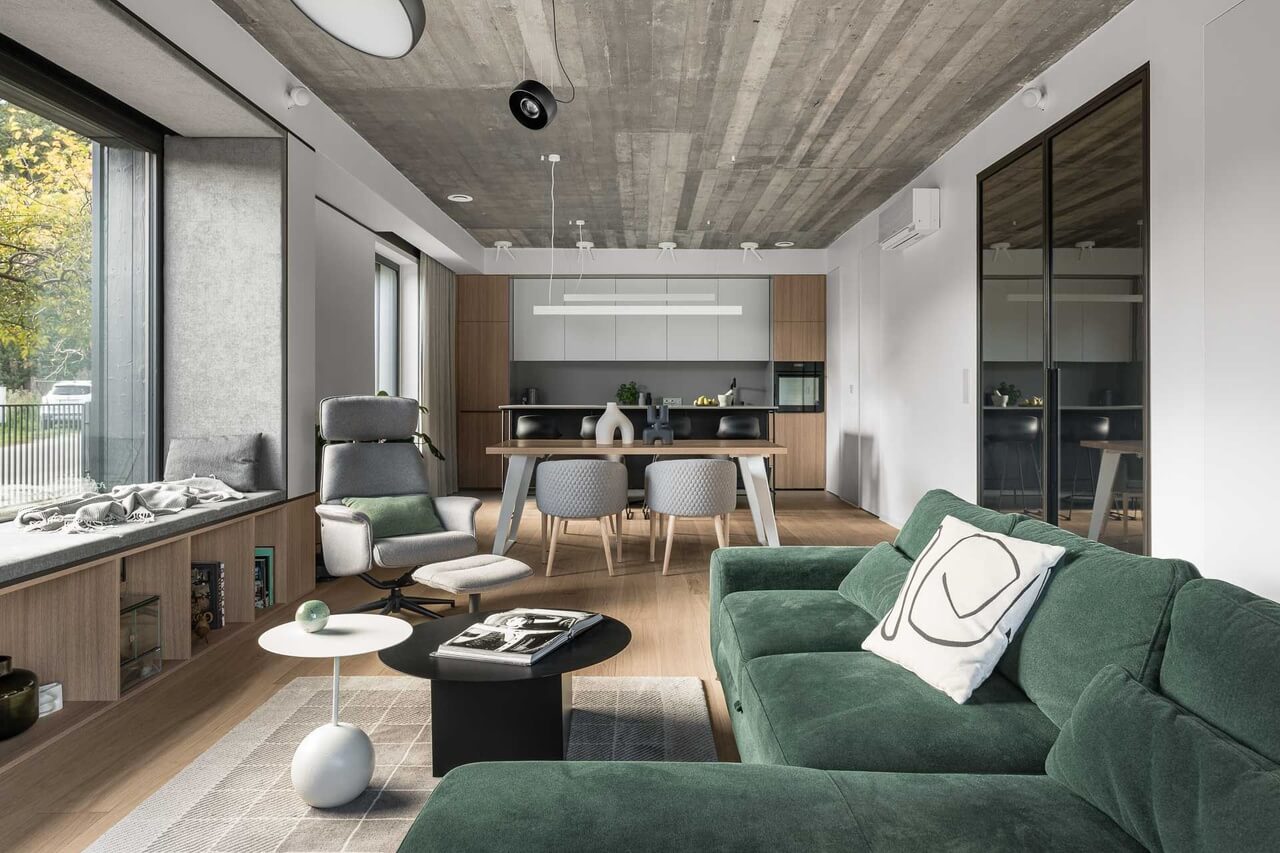 Nowoczesny salon z zieloną sofą i minimalistyczną jadalnią.