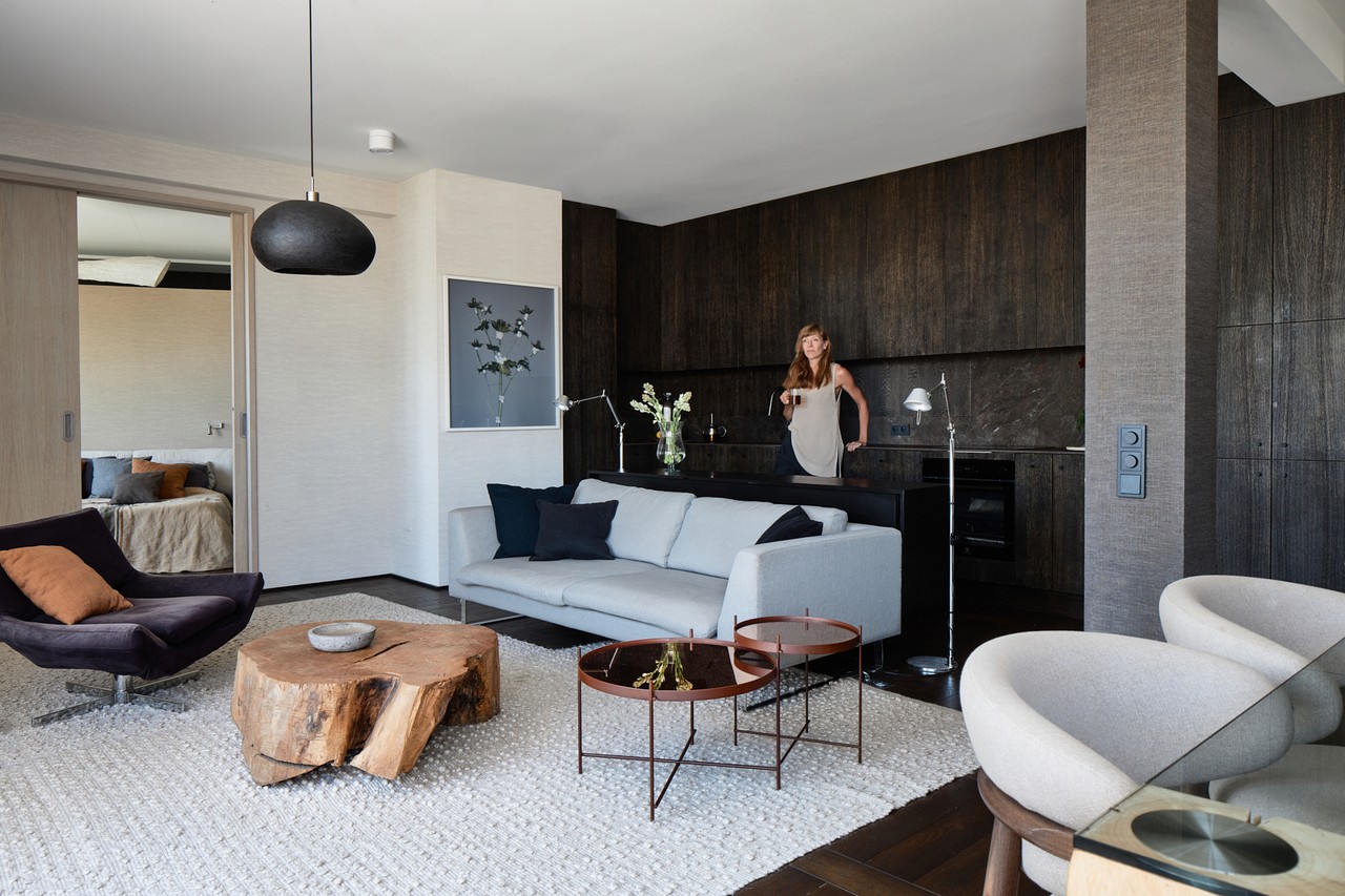 Nowoczesny salon z designerskimi meblami i drewnianymi akcentami.