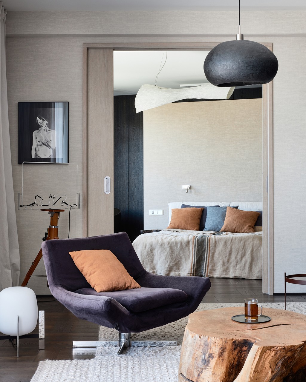 Stylowy salon z designerskim fotelem i naturalnym drewnianym stolikiem.