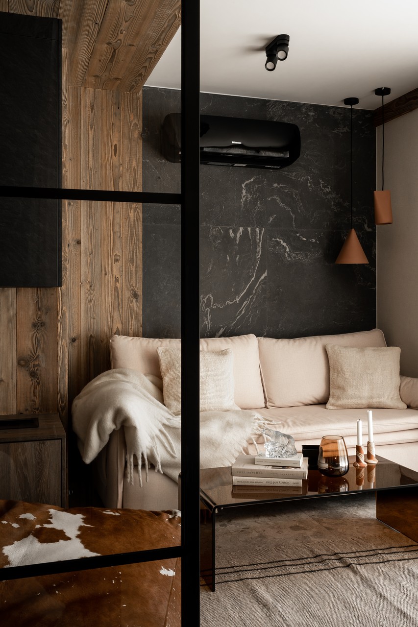 Elegancki salon z drewnianymi akcentami i stylowymi dodatkami.