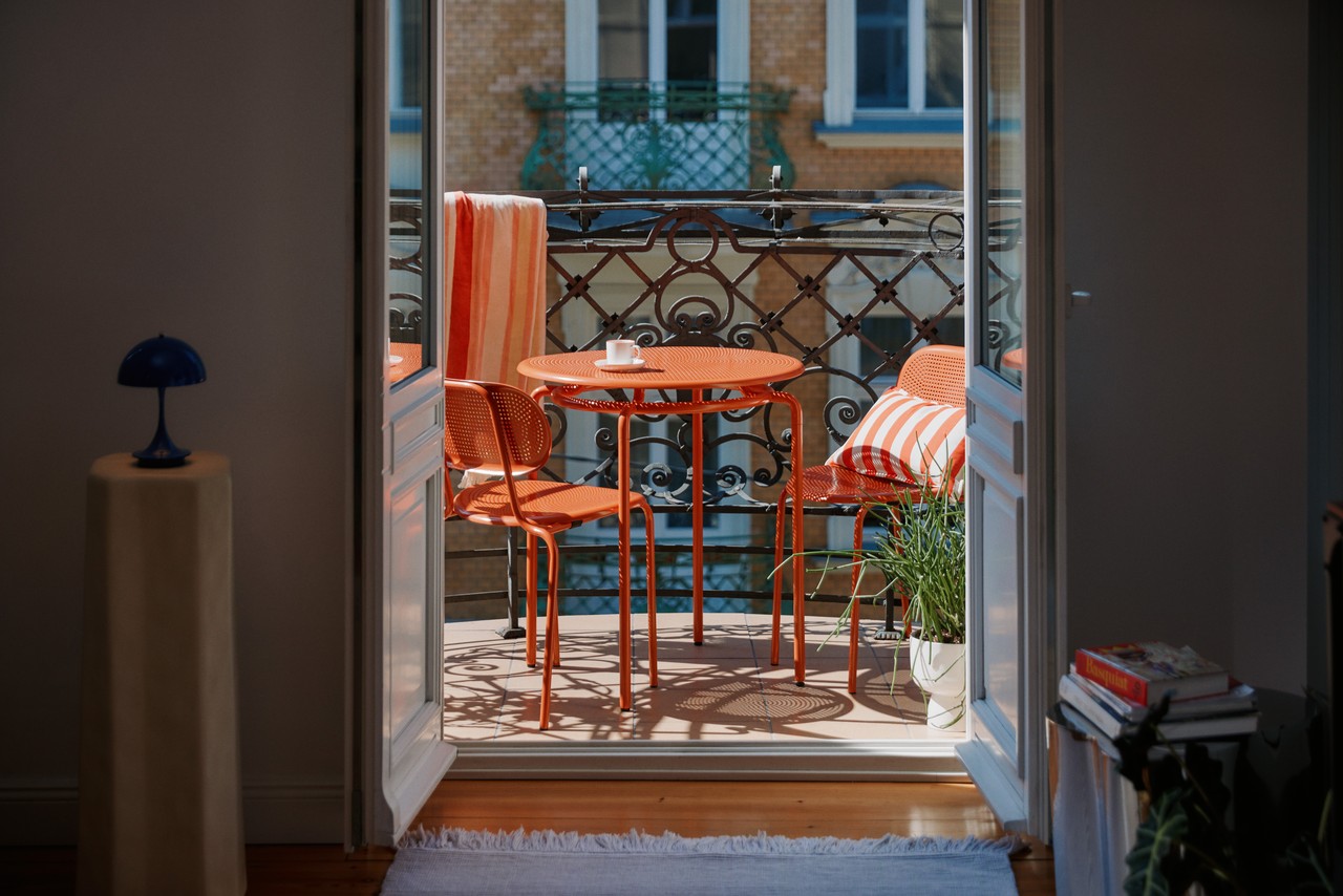 Balkon z czerwonym zestawem mebli, idealny do relaksu na świeżym powietrzu.