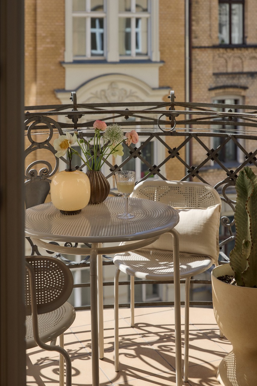 Balkon w stylu vintage z okrągłym stolikiem i dekoracjami.