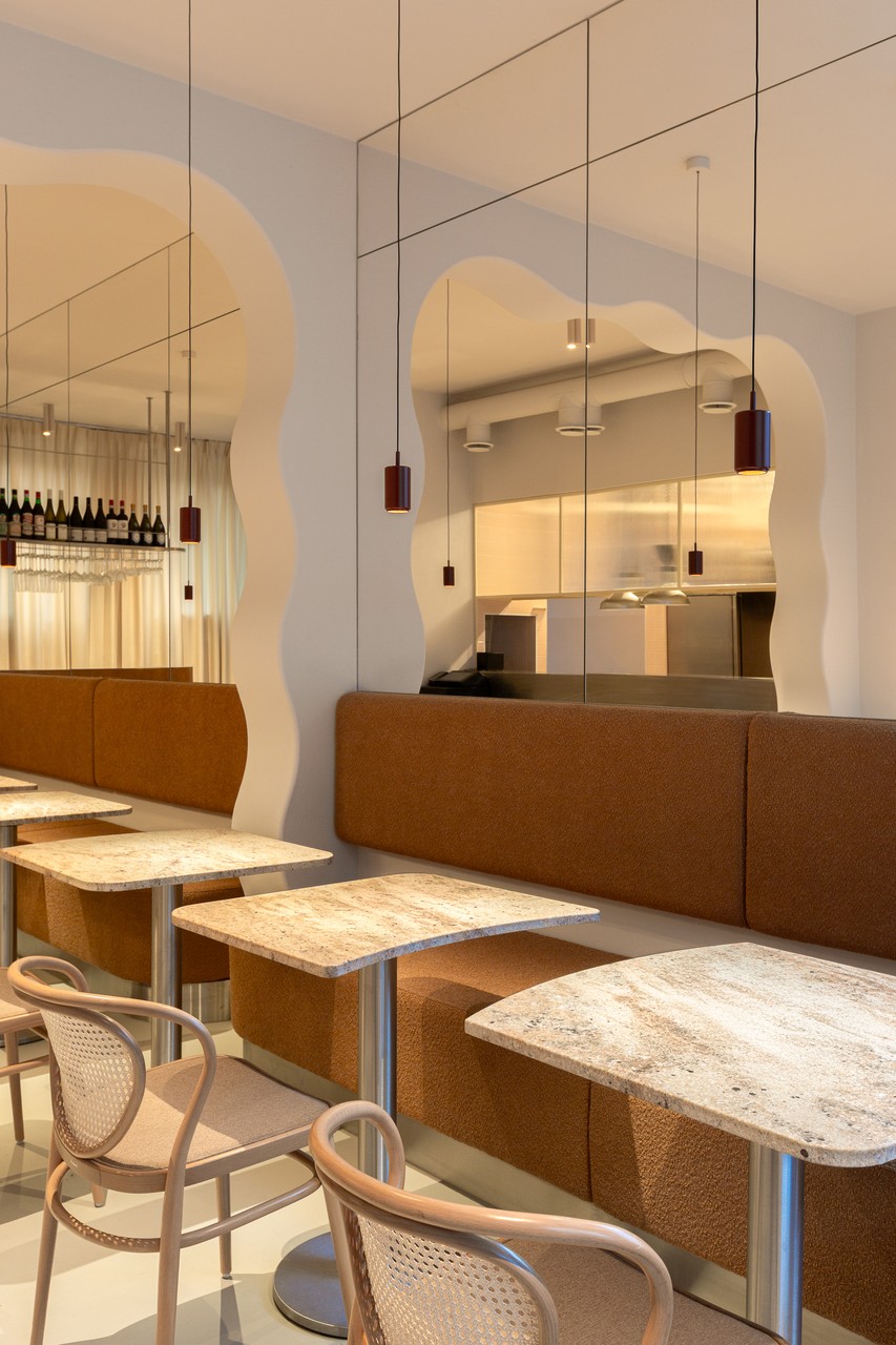 Elegancka restauracja z marmurowymi stolikami i nowoczesnym designem.