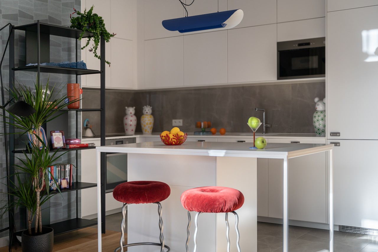 Nowoczesna kuchnia z wyspą i kolorowymi akcentami, funkcjonalny design.