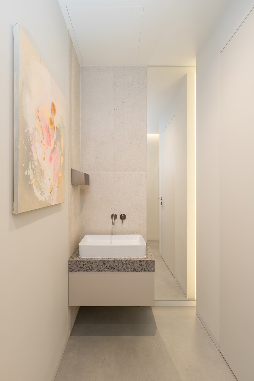 Nowoczesna łazienka z designerską umywalką i sztuką ścienną.