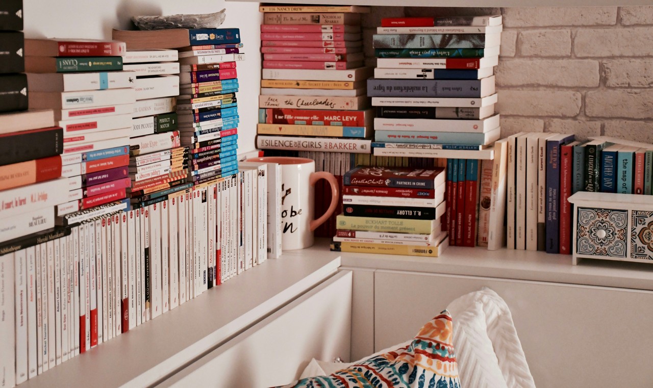 Półka z książkami w przytulnym wnętrzu domowej biblioteki.