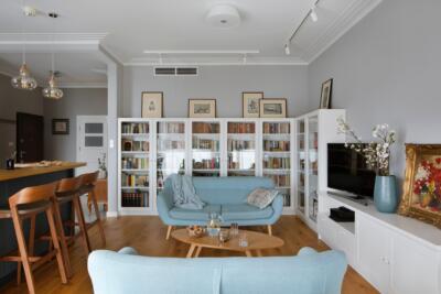 Spacious living room with wooden floors and glass display cases.
