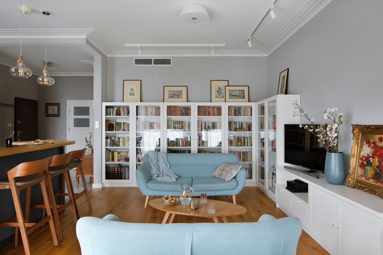 Spacious living room with wooden floors and glass display cases.