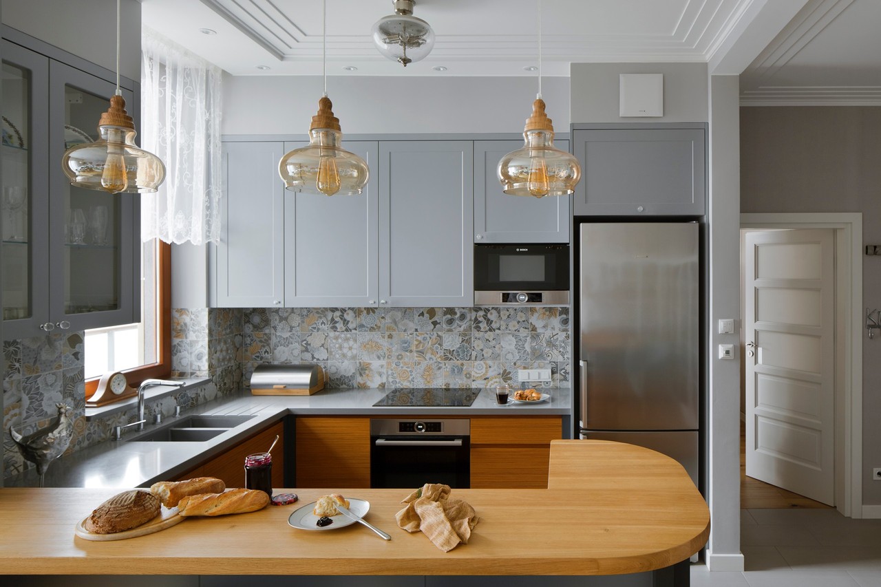 Modern kitchen with wooden countertop and stylish lamps.