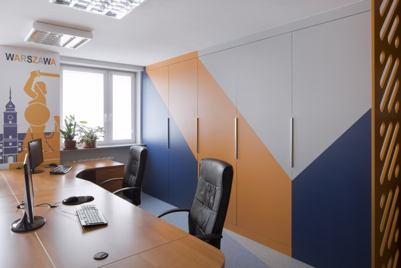 Modern office with colorful cabinets and elegant chairs.
