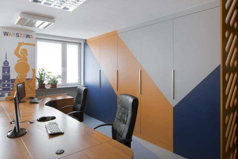 Modern office with colorful cabinets and elegant chairs.