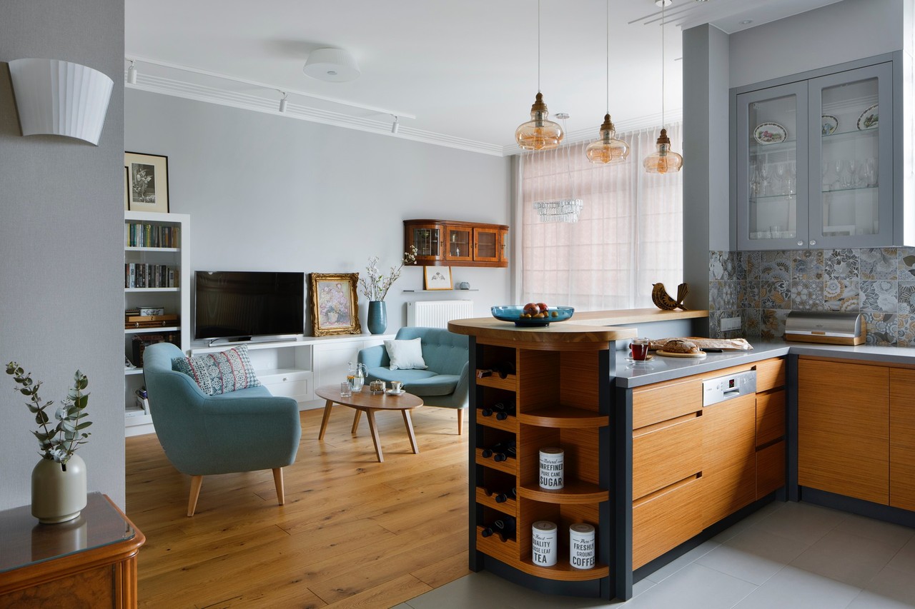 Elegant living room with wooden floor and blue chairs.