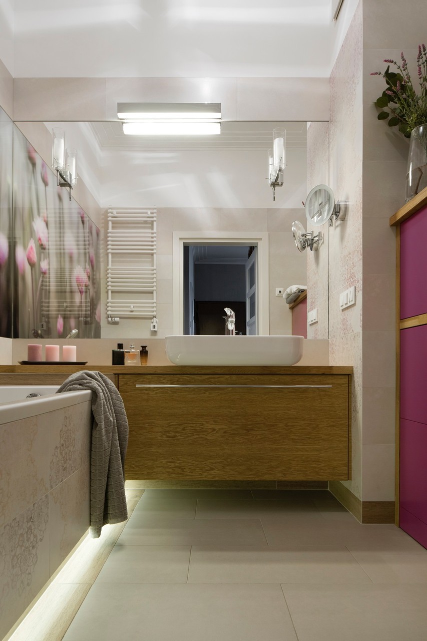 Modern bathroom with wooden cabinet and fashionable lighting.