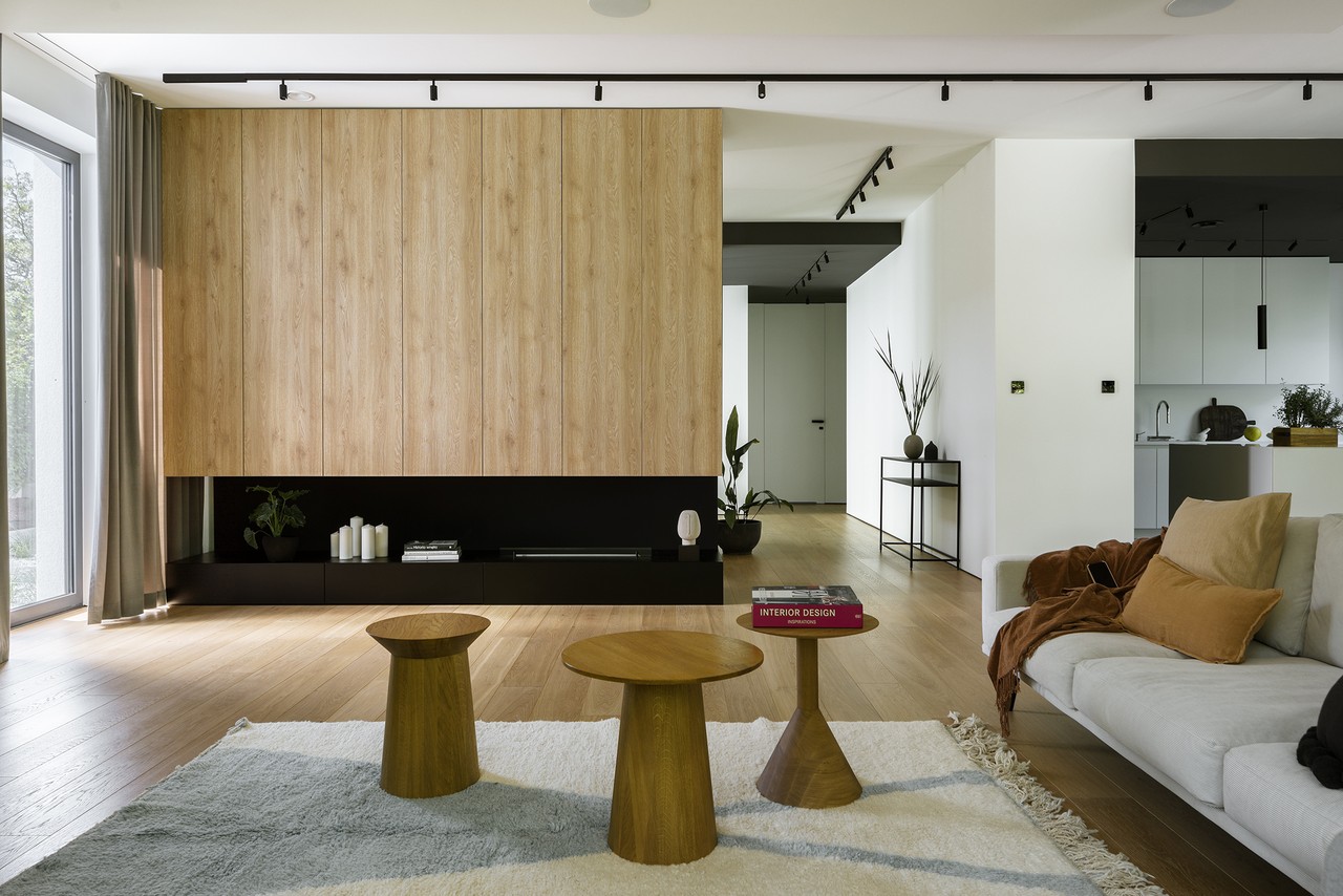 A modern living room with wooden built-in and designer tables.