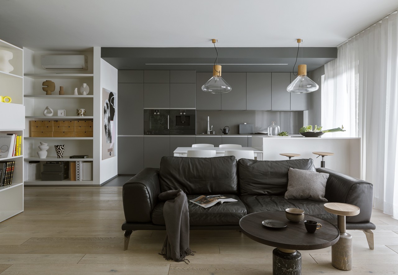Modern living room with open kitchen and minimalist details.