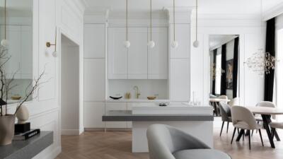 Modern kitchen with white cabinetry and wood flooring.