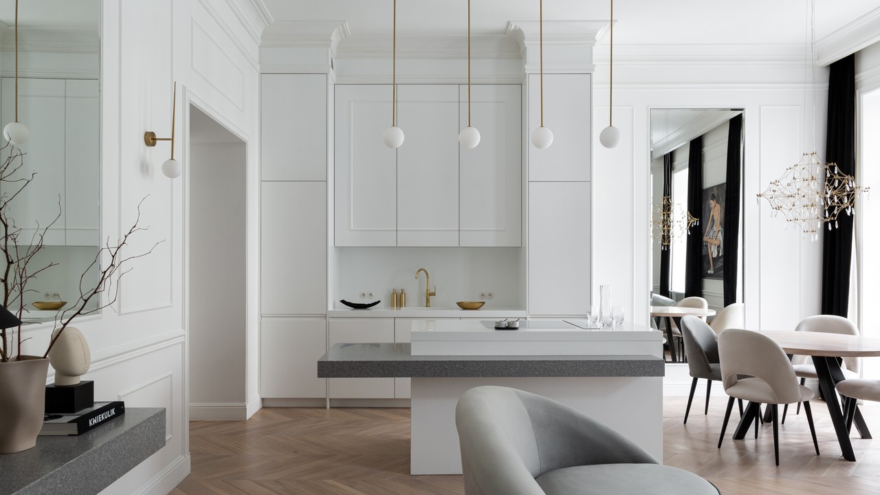 Modern kitchen with white cabinetry and wood flooring.