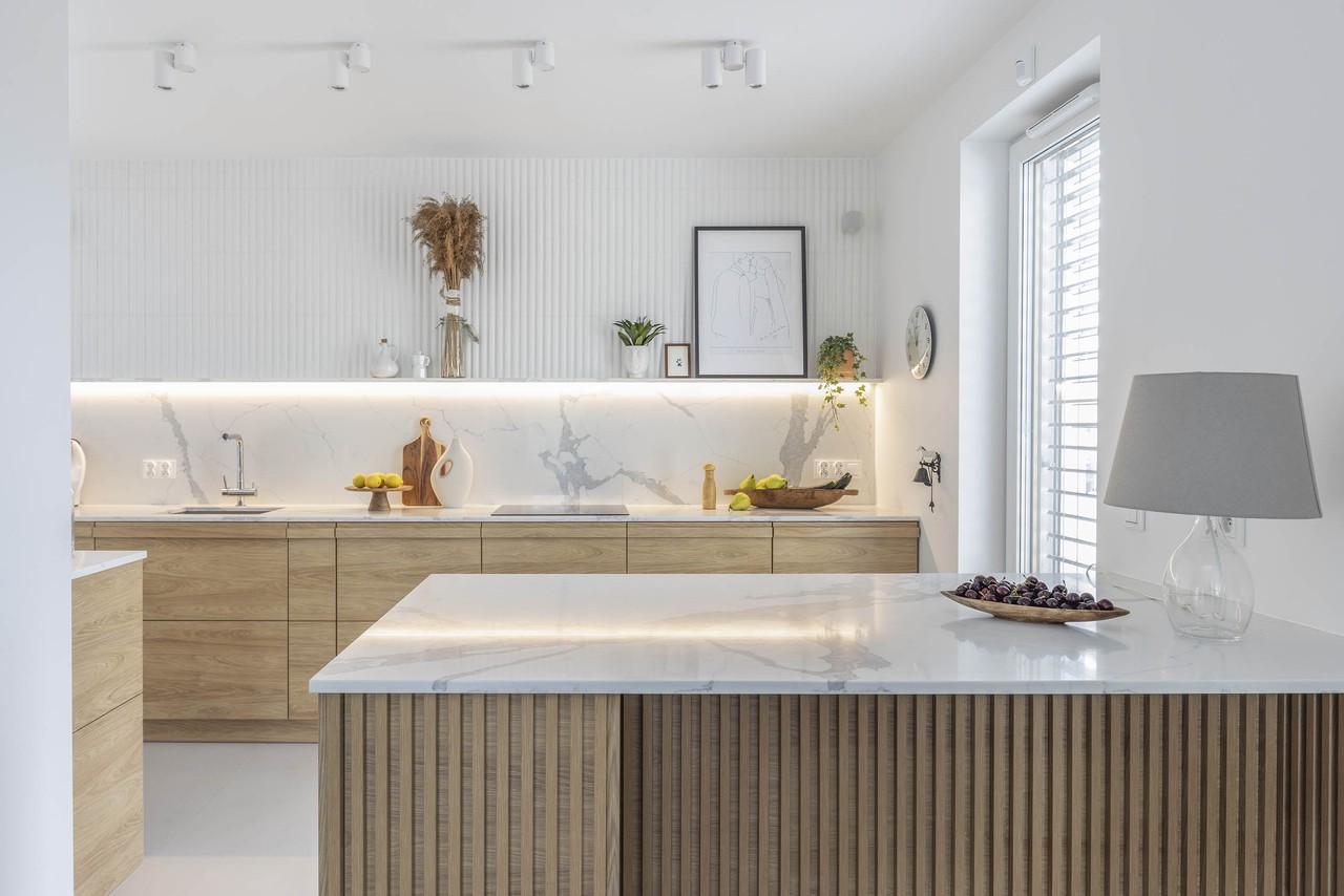 Modern kitchen with wooden fronts and marble countertop.