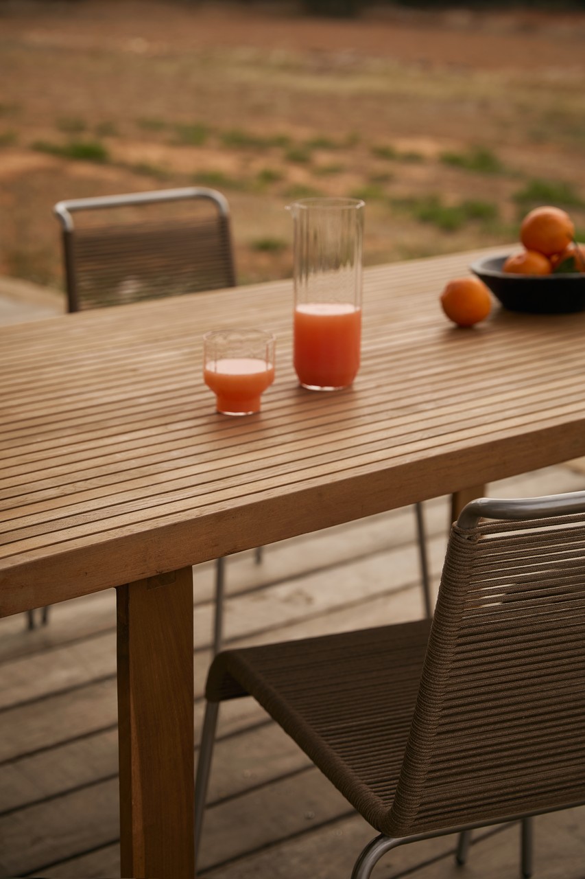 Drewniany stół z sokiem i pomarańczami, nowoczesny design patio.
