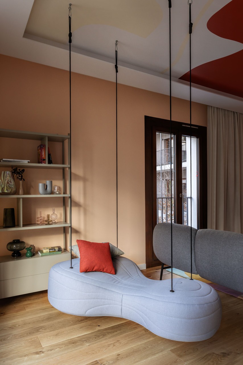 Zawieszona sofa w nowoczesnym wnętrzu z drewnianą podłogą.