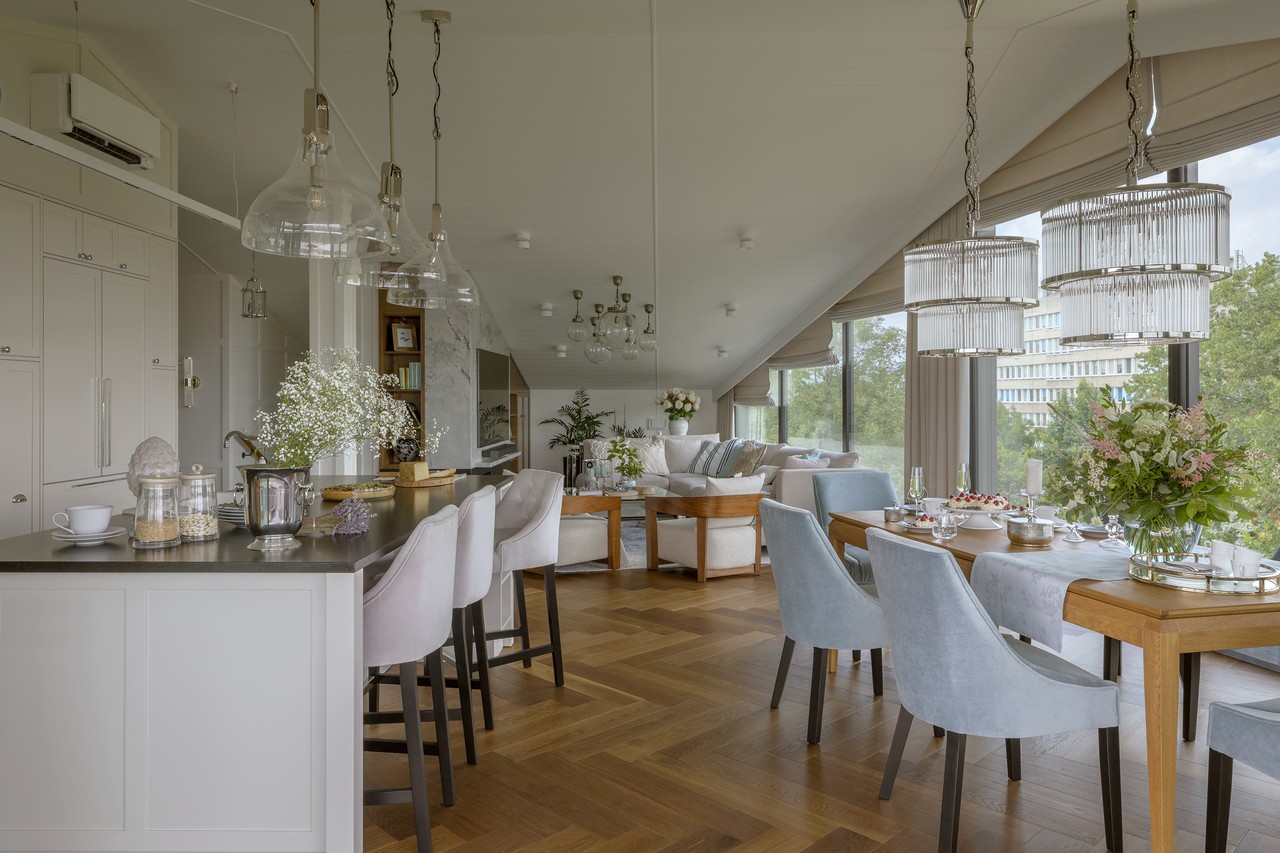Przestronny salon z elegancką jadalnią i designerskimi lampami.