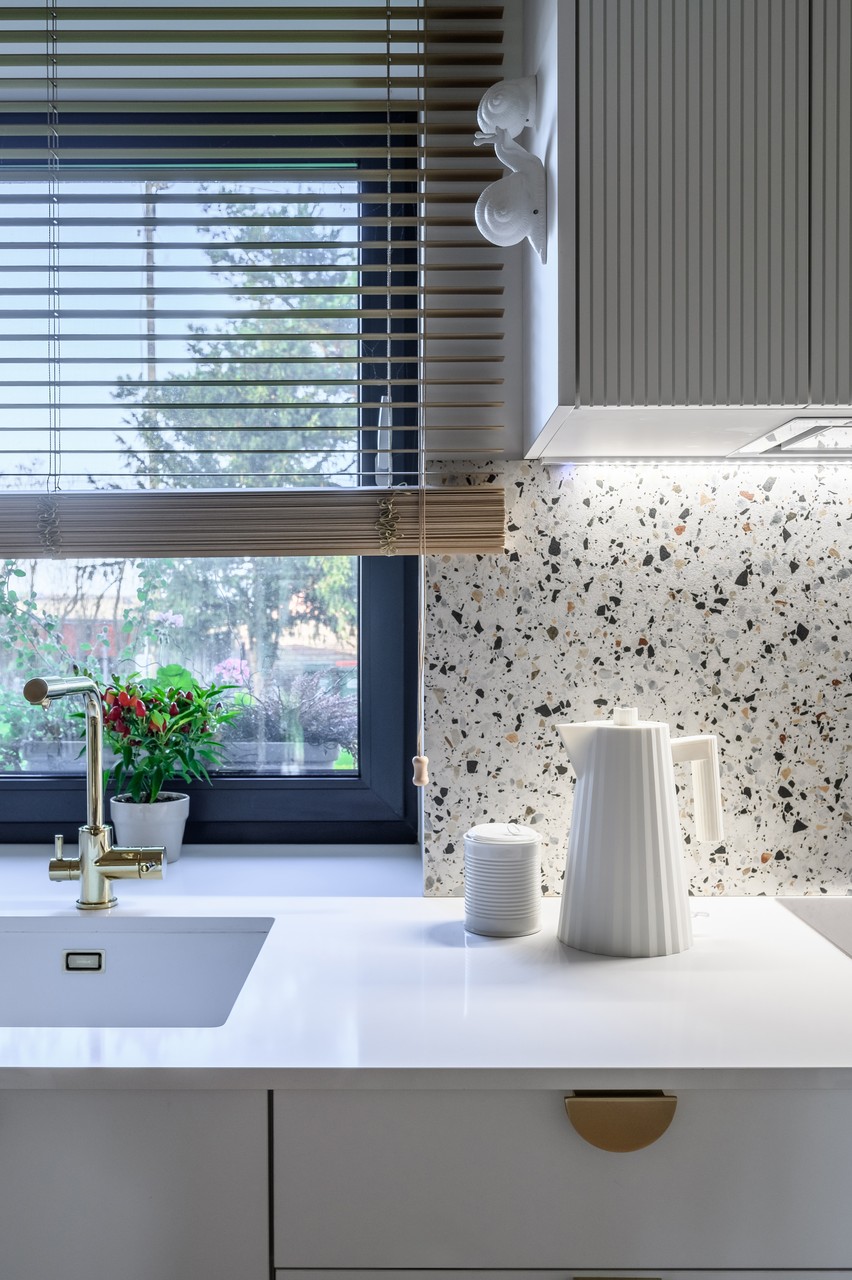 Nowoczesna kuchnia z terrazzo i eleganckim kranem.