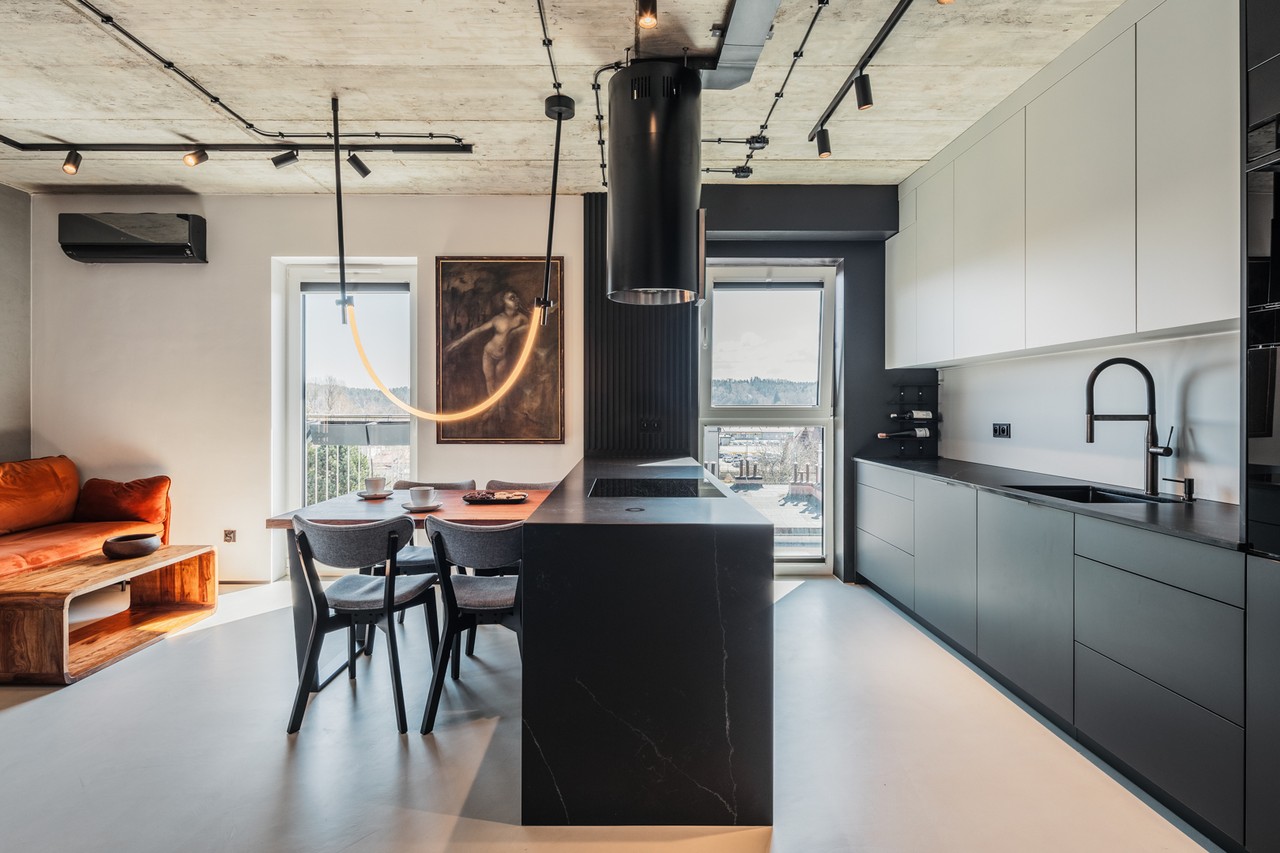 Nowoczesna kuchnia z wyspą i designerskim stołem w industrialnym stylu.