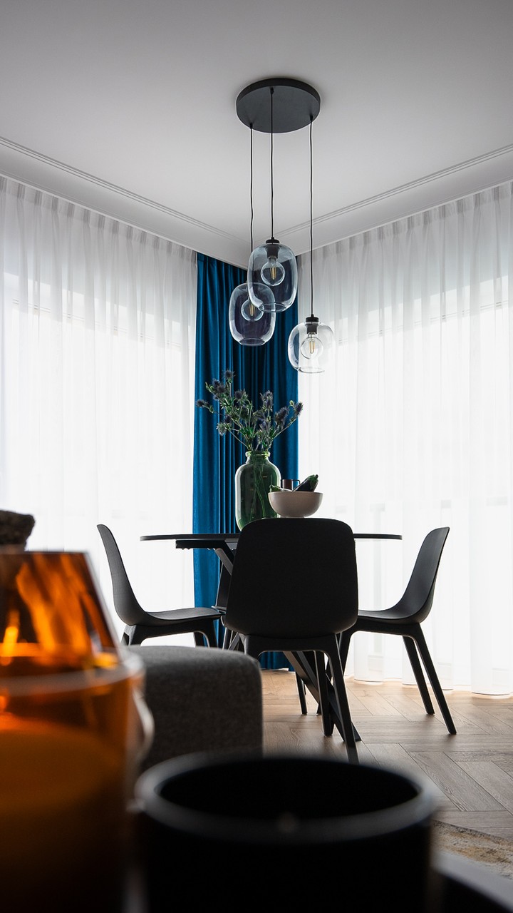 Elegancka jadalnia z designerskimi lampami i nowoczesnymi krzesłami.