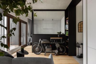 Stylowy salon z motocyklowym dekorem i zielenią.