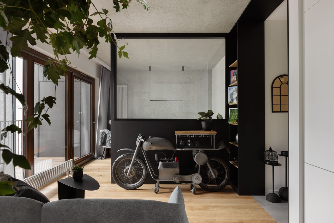 Stylowy salon z motocyklowym dekorem i zielenią.