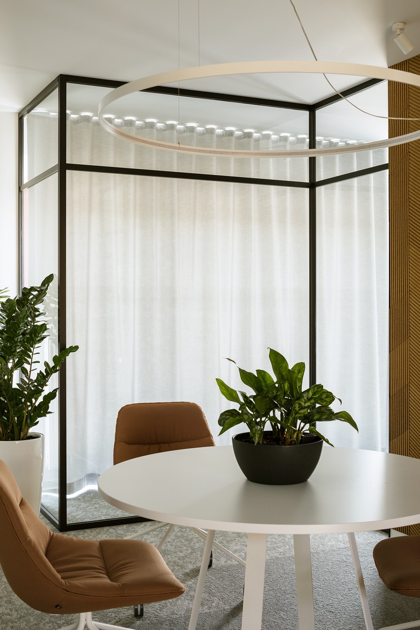 Nowoczesna przestrzeń biurowa z zielenią i designerskimi meblami.