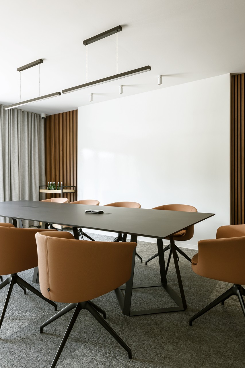 Nowoczesna sala konferencyjna z eleganckimi krzesłami i stołem.