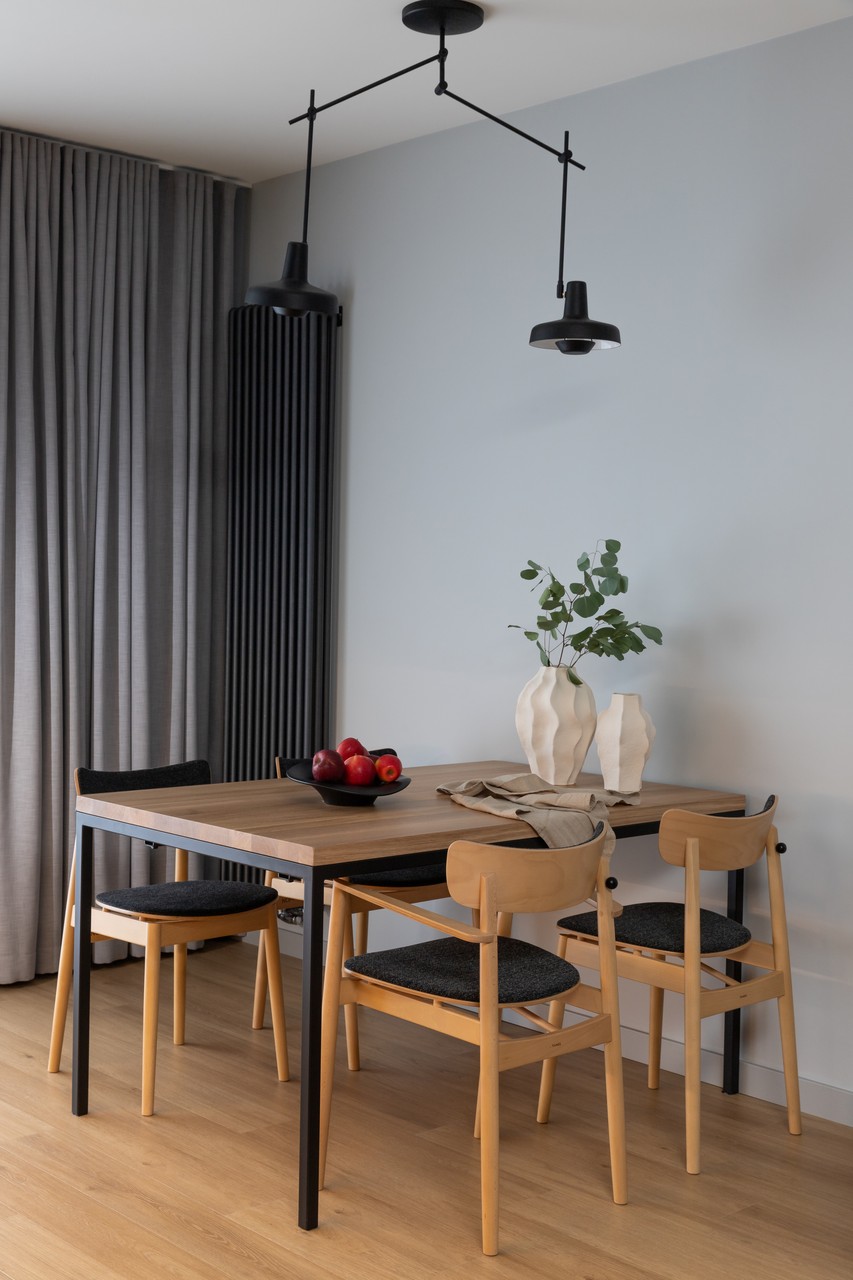 Nowoczesna jadalnia z drewnianym stołem i designerskimi krzesłami.