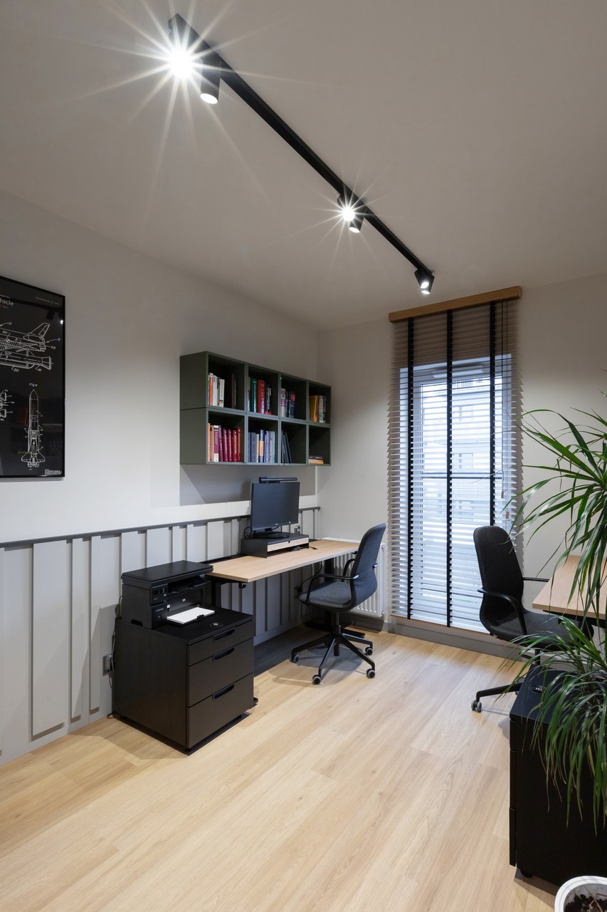 Nowoczesne biuro z minimalistycznym designem i drewnianą podłogą.