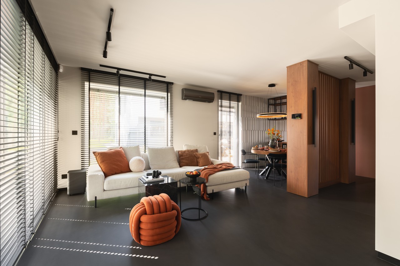 Nowoczesny salon z sofą i stylową jadalnią.