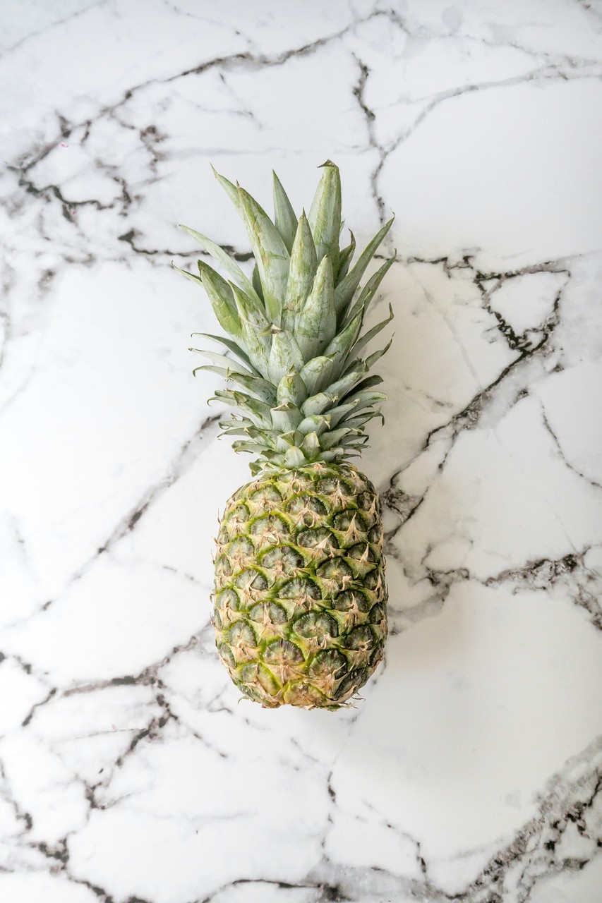 Ananas na stole z eleganckiego marmuru w nowoczesnym stylu.