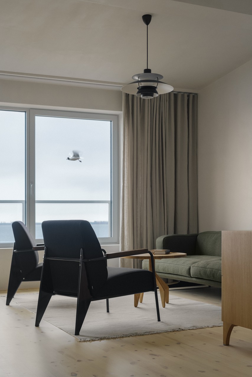 Nowoczesny salon z panoramicznym oknem i stylowymi meblami.