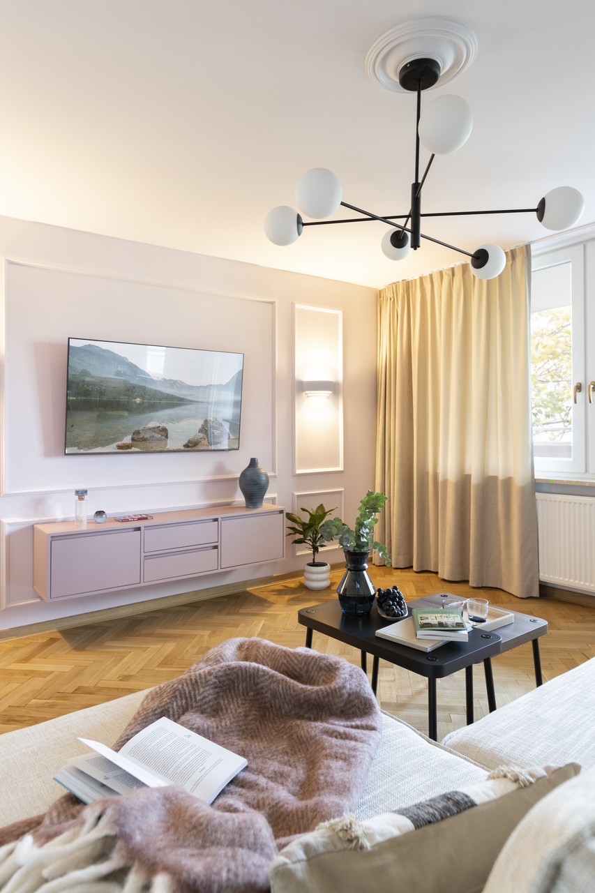 Przytulny salon z nowoczesnym oświetleniem i stylowymi detalami.